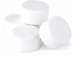 Kleine weiße Chlortabletten zur Poolreinigung und Wasserbalance.