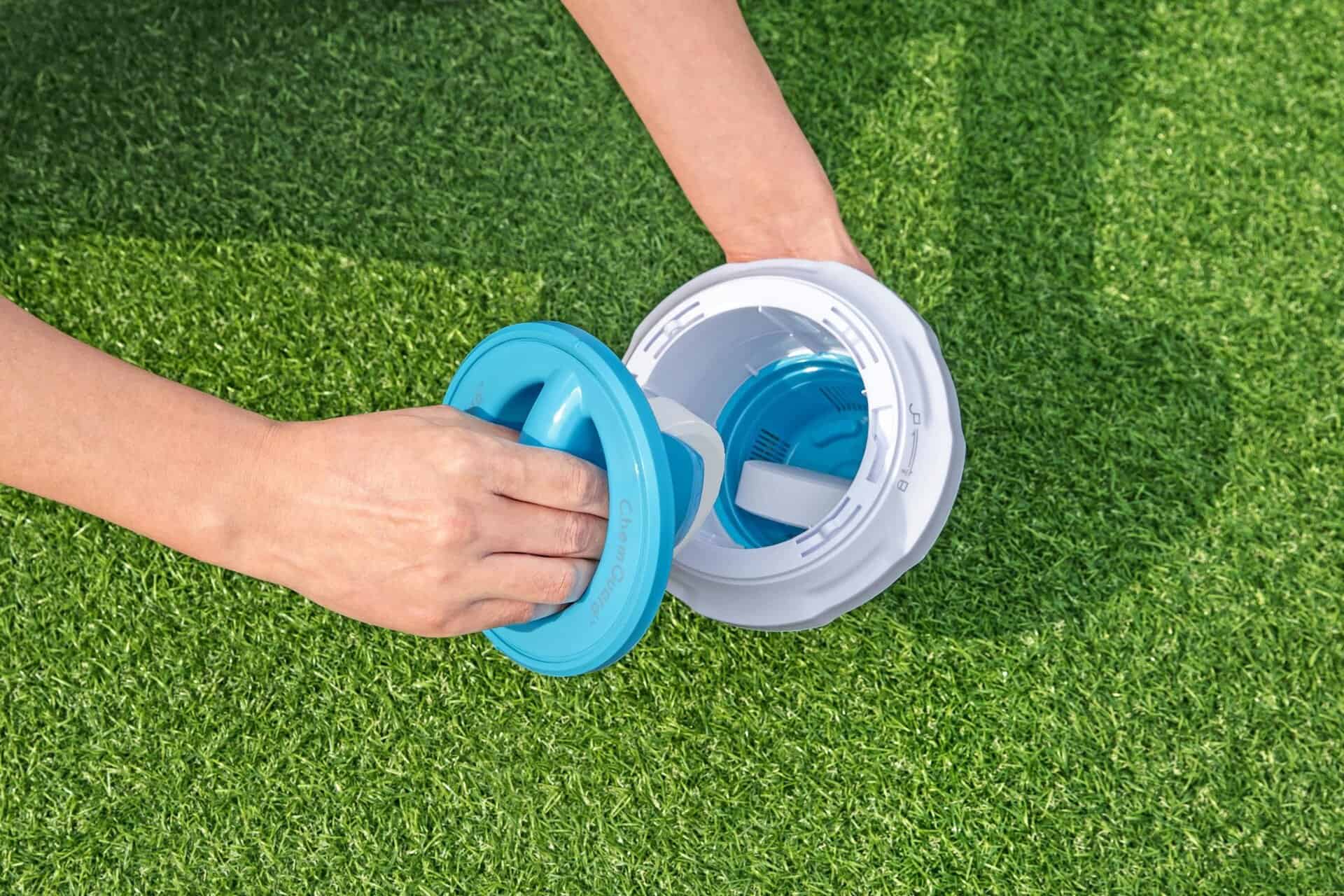 Klappbarer Chlordispenser mit ChemGuard-Handschuh auf Gras.
