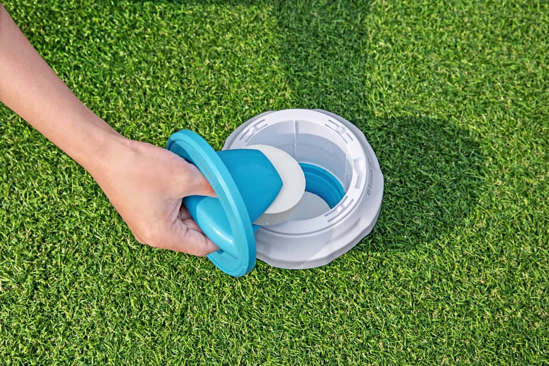 Klappbarer Chlordispenser mit ChemGuard-Handschuh auf Gras.