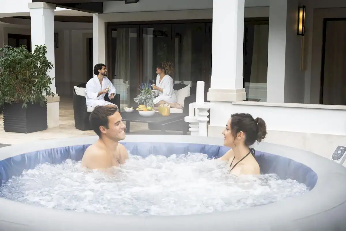 Zwei Personen genießen den Lay-Z Spa Santorini HydroJet Pro WiFi im Garten.