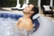 Mann entspannt im aufblasbaren Spa mit Hydrojets und WiFi-Steuerung.