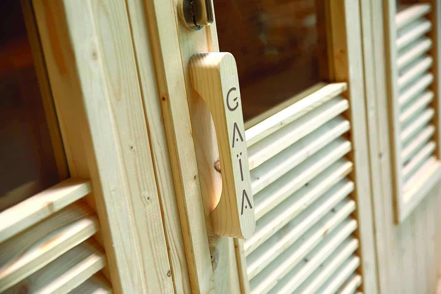 Außensauna mit Holztür und Belüftungsgitter, luxuriöses Saunazubehör.