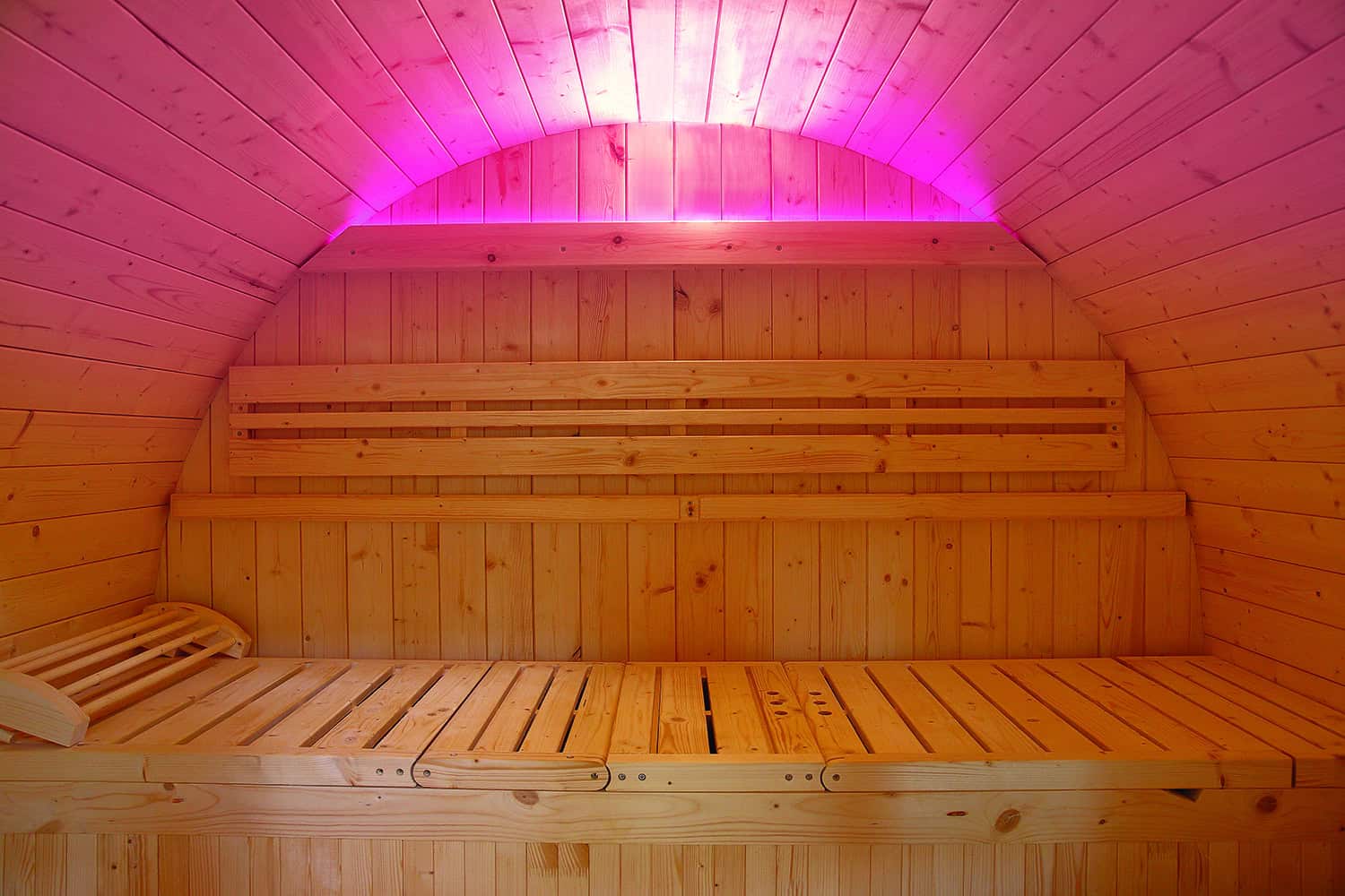 Luxuriöse Außensauna mit LED-Beleuchtung und Holzinterieur.