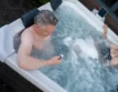 Entspannter Mann in der Spa mit Smartphone, genießt den Komfort.