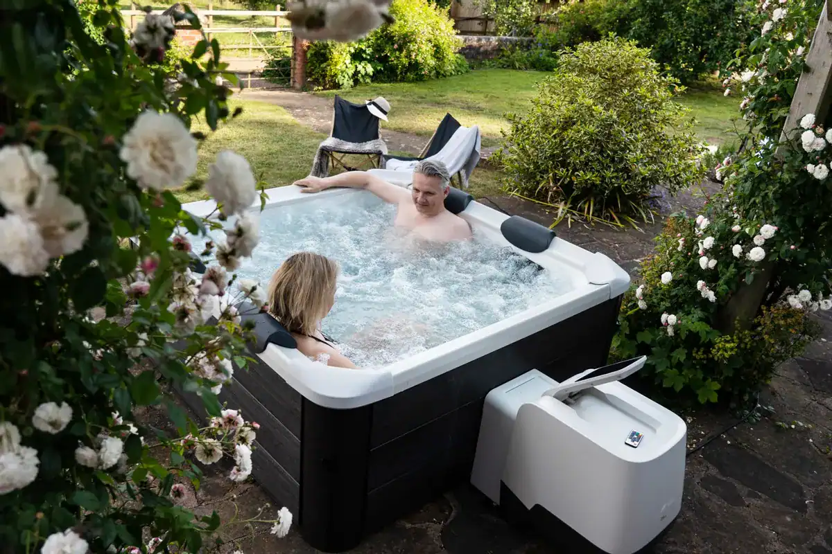 Luxuriöse 6-Personen aufblasbare Spa im Garten mit umgebenden Blumen.