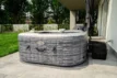 Luxuriöser Außenwhirlpool auf der Terrasse mit Garten und Gartenmöbeln.