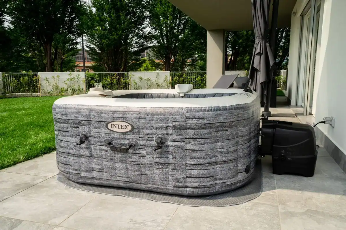 Luxuriöser Außenwhirlpool auf der Terrasse mit Garten und Gartenmöbeln.