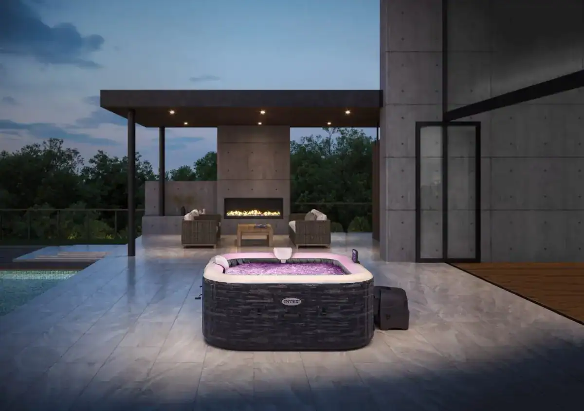 Luxuriöser Außenwhirlpool auf der Terrasse mit bequemen Loungesesseln und offenem Kamin.