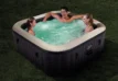 Familien genießen einen aufblasbaren Whirlpool im Garten.