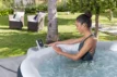 Schwimmer im Whirlpool mit Bedienpanel im Garten, entspannt und genießt die frische Luft.
