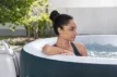 Luxuriöser Hot Tub mit Frau, die im Gartenbad entspannt, ideal für Wellness zu Hause.