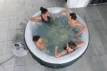 Freunde genießen einen Hot Tub auf einer Terrasse.