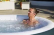 Mann entspannt in einem aufblasbaren Pool draußen an einem sonnigen Tag.