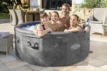 Familien genießen den Lay-Z Spa Carrara Airjet im Freien.