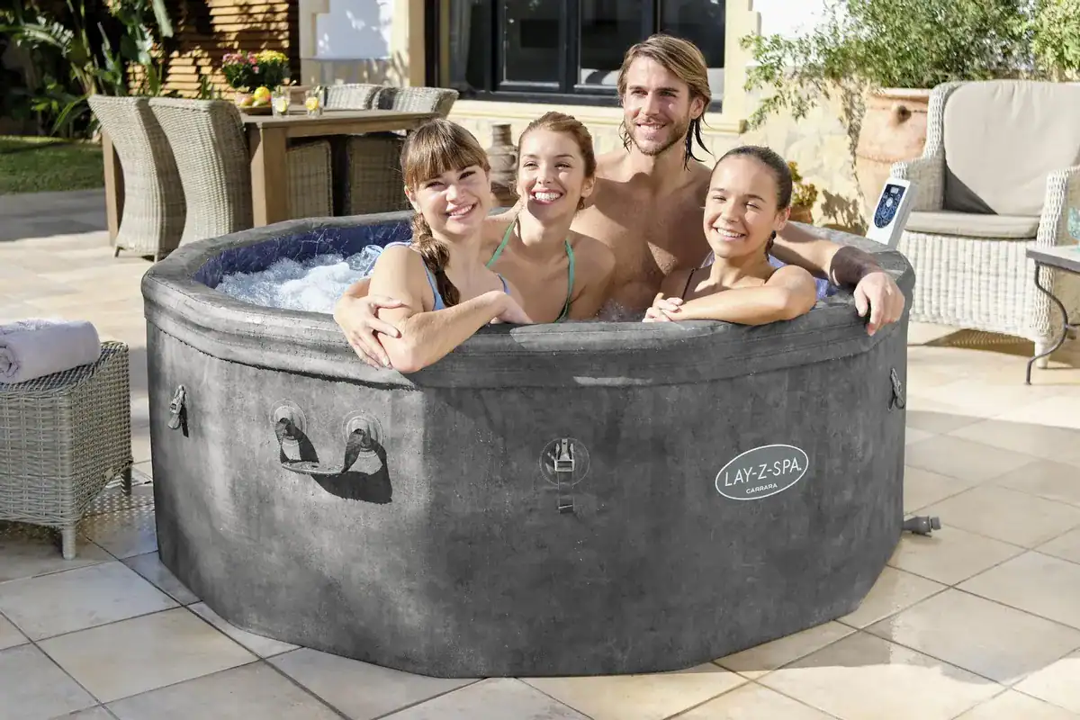 Familien genießen den Lay-Z Spa Carrara Airjet im Freien.