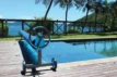 Poolwasser und Pool mit Blick auf tropische Landschaft und Palmen.