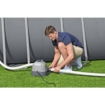 Mann verwendet automatischen Poolroboter zur Reinigung des Pools.
