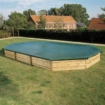 Pool mit Holzverkleidung und Abdeckung im Garten.